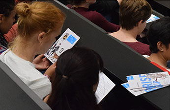 Students in a lecture theatre with Careers branded leaflets