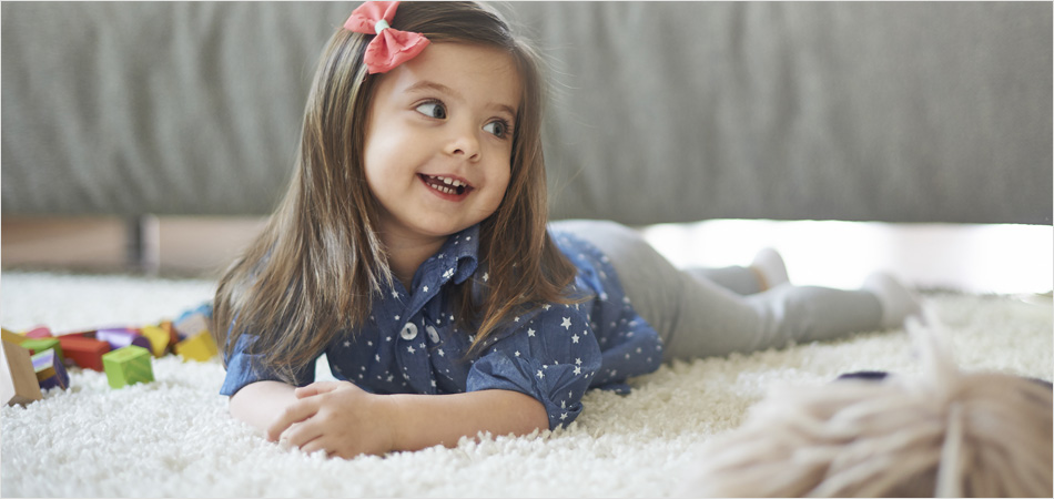 VAX floorcare – young girl lying on a soft cream carpet/rug