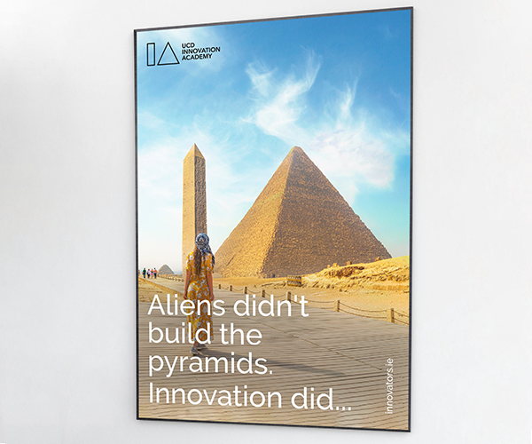Poster mockup with photo of an obelisk and a pyramid side by side, making them resemble the IA of the Innovation Academy logo. A tourist, seen from behind, looks on at the monuments as if in wonder. 