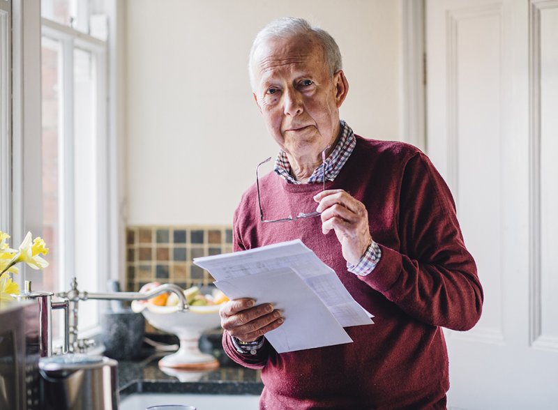 Image of an elderly gentleman looking at some household bills