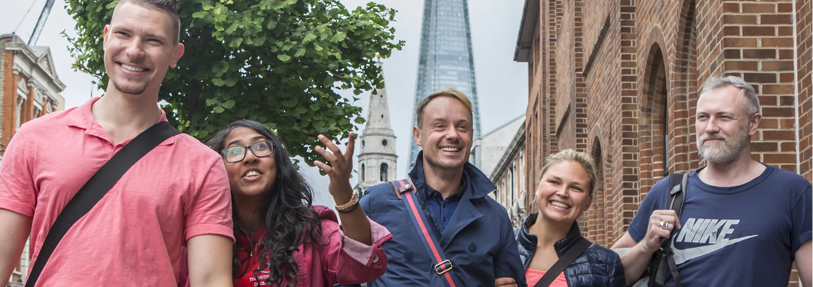 Osteopathy students walking along the street in London, with The Shard building visible behind them