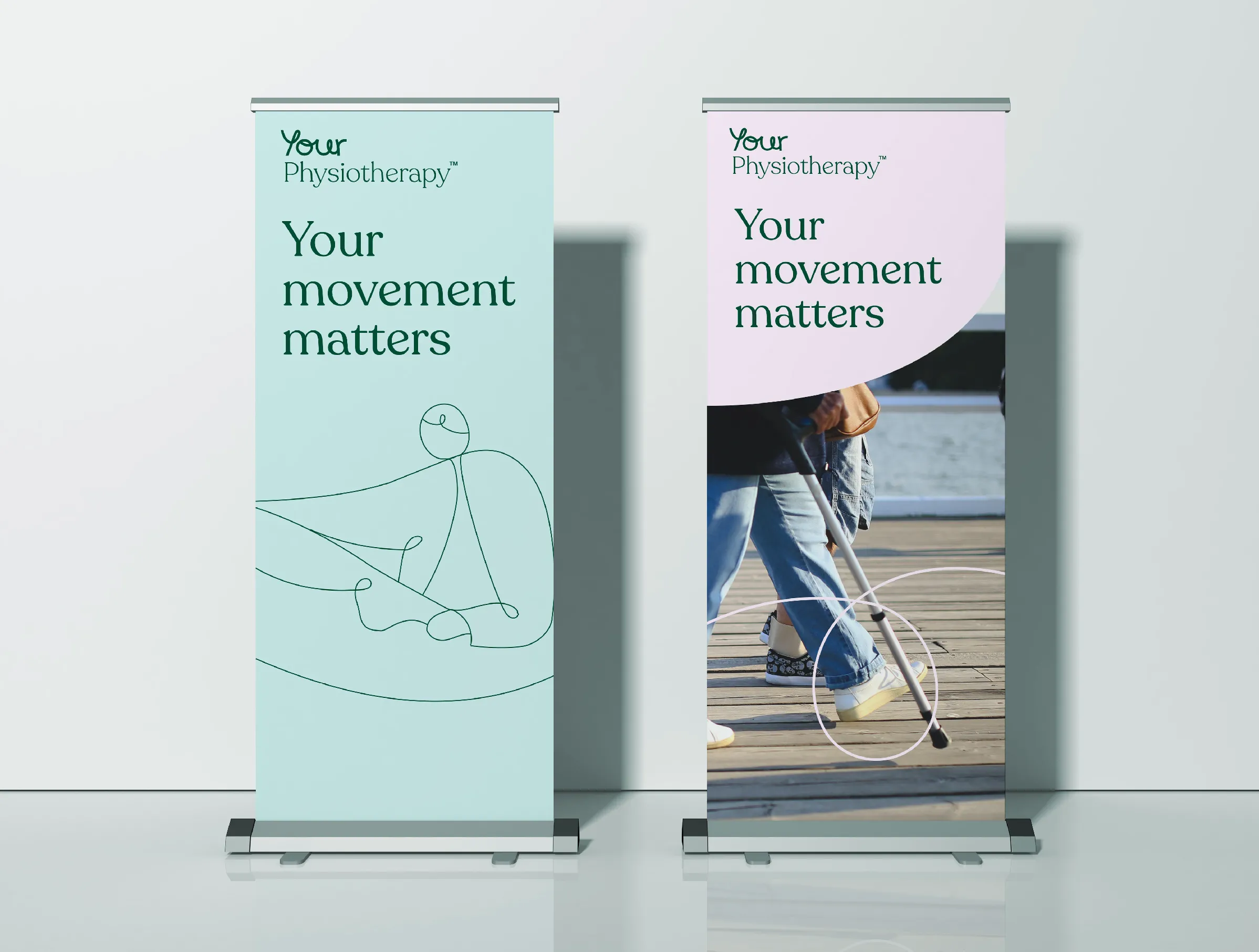 Banner stands showing Your Physiotherapy branding and the strapline Your movement matters. One features an illustration of a physio at work. The other shows a photo of two people walking along a pier or boardwalk, from the waist down. One is using a walking stick. 