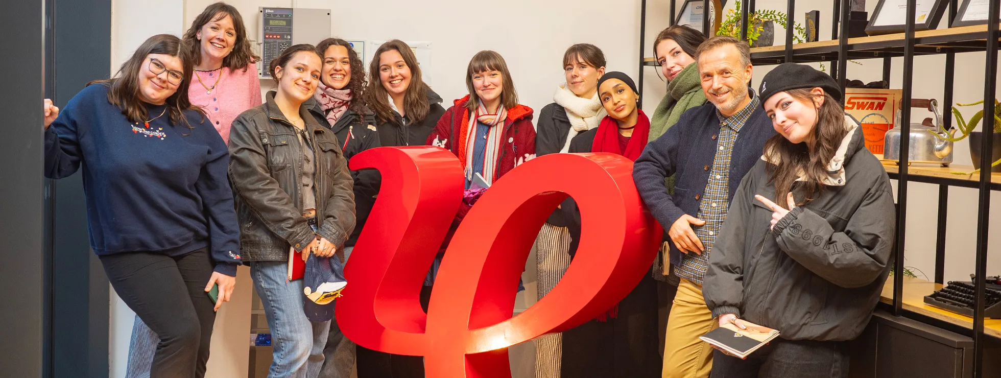 Ollie, Josie and Amber with placement students stood around the 3D IE logo